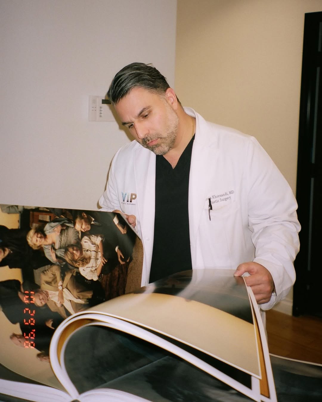 Editorial photo of Dr. Khorsandi reviewing a magazine layout